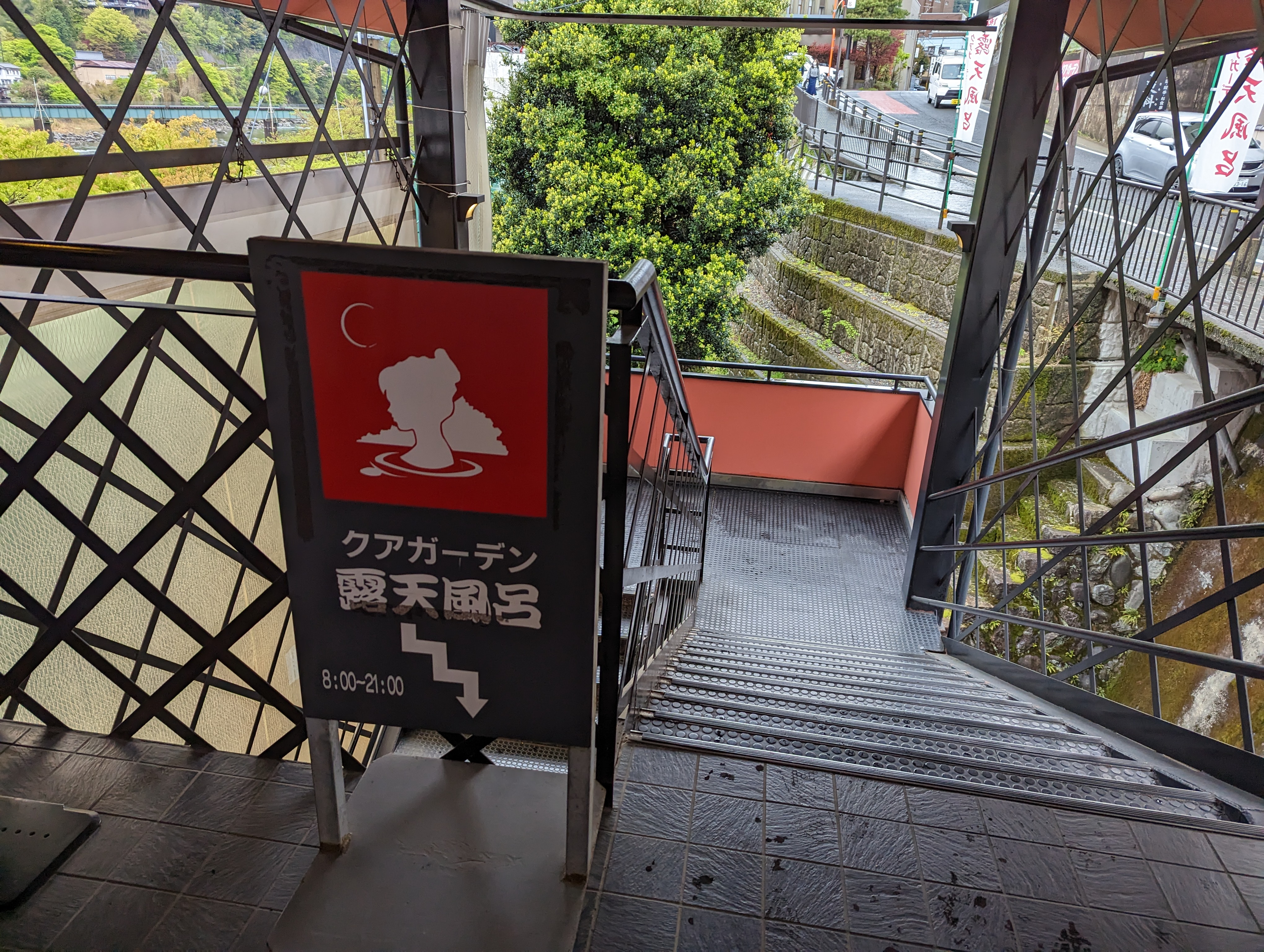 クアガーデン露天風呂の案内看板と露天風呂へ下りる階段