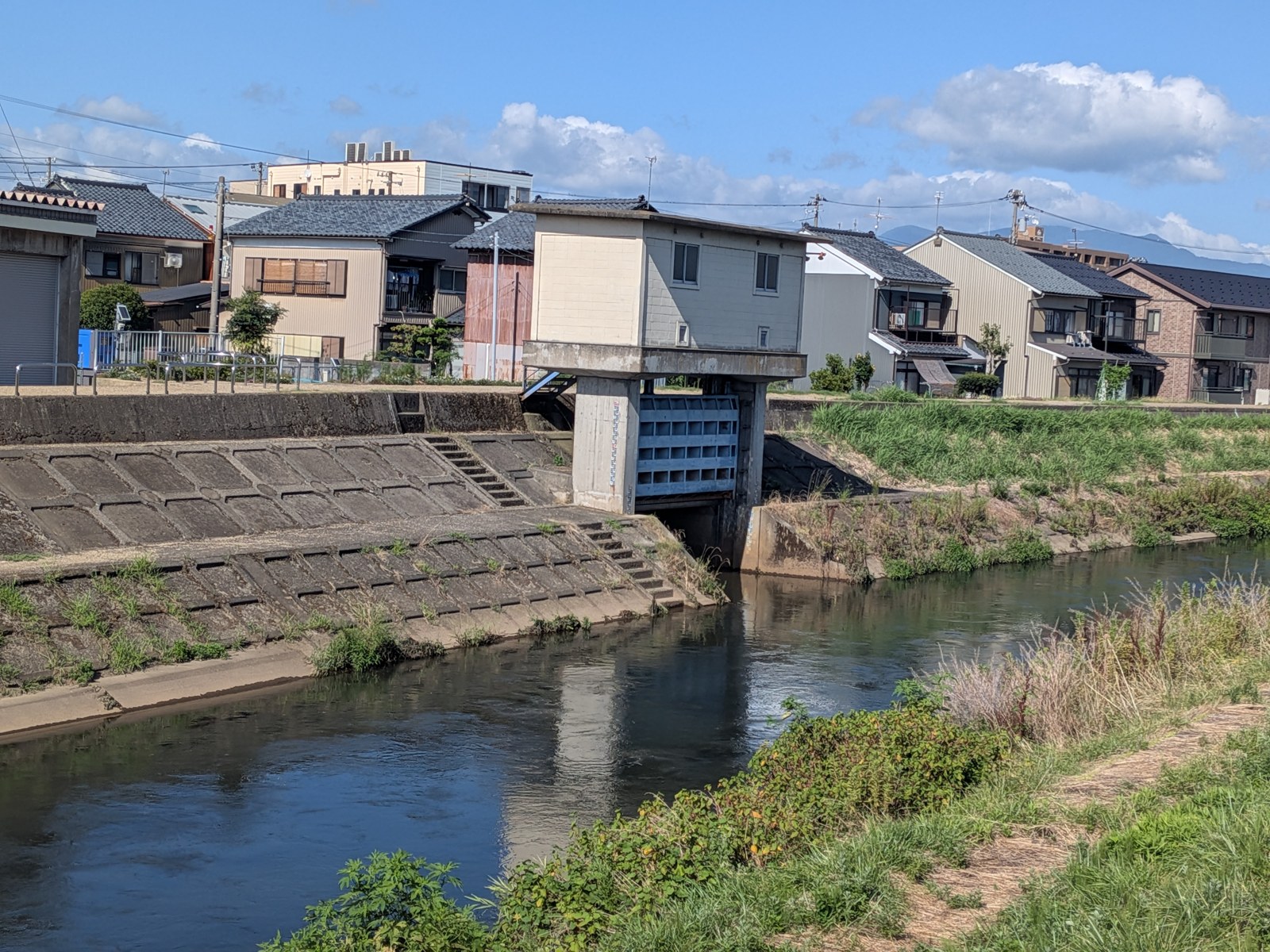 荒川の水門と住宅街の風景