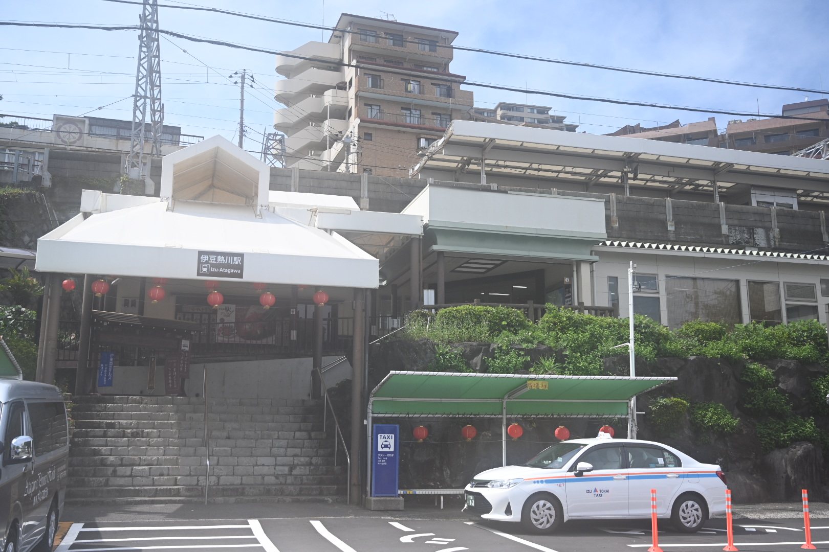 伊豆熱川駅の駅舎と赤い提灯、駅前のタクシー乗り場