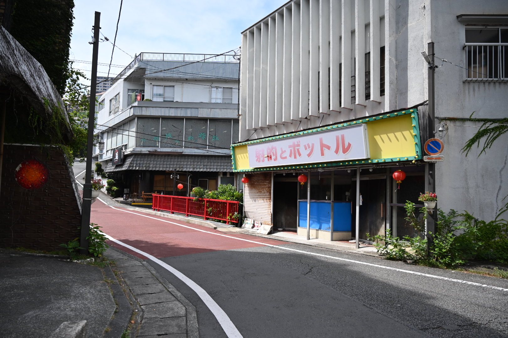 熱川温泉の「射的とボットル」の看板と赤い欄干の橋がある角