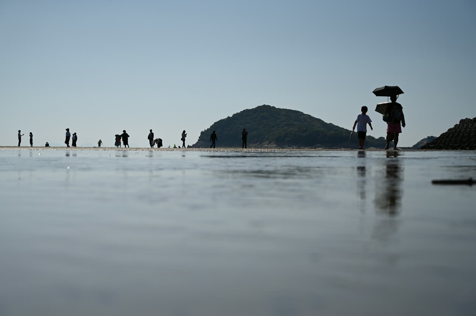 父母ヶ浜の潮だまりに映る人のシルエットと空