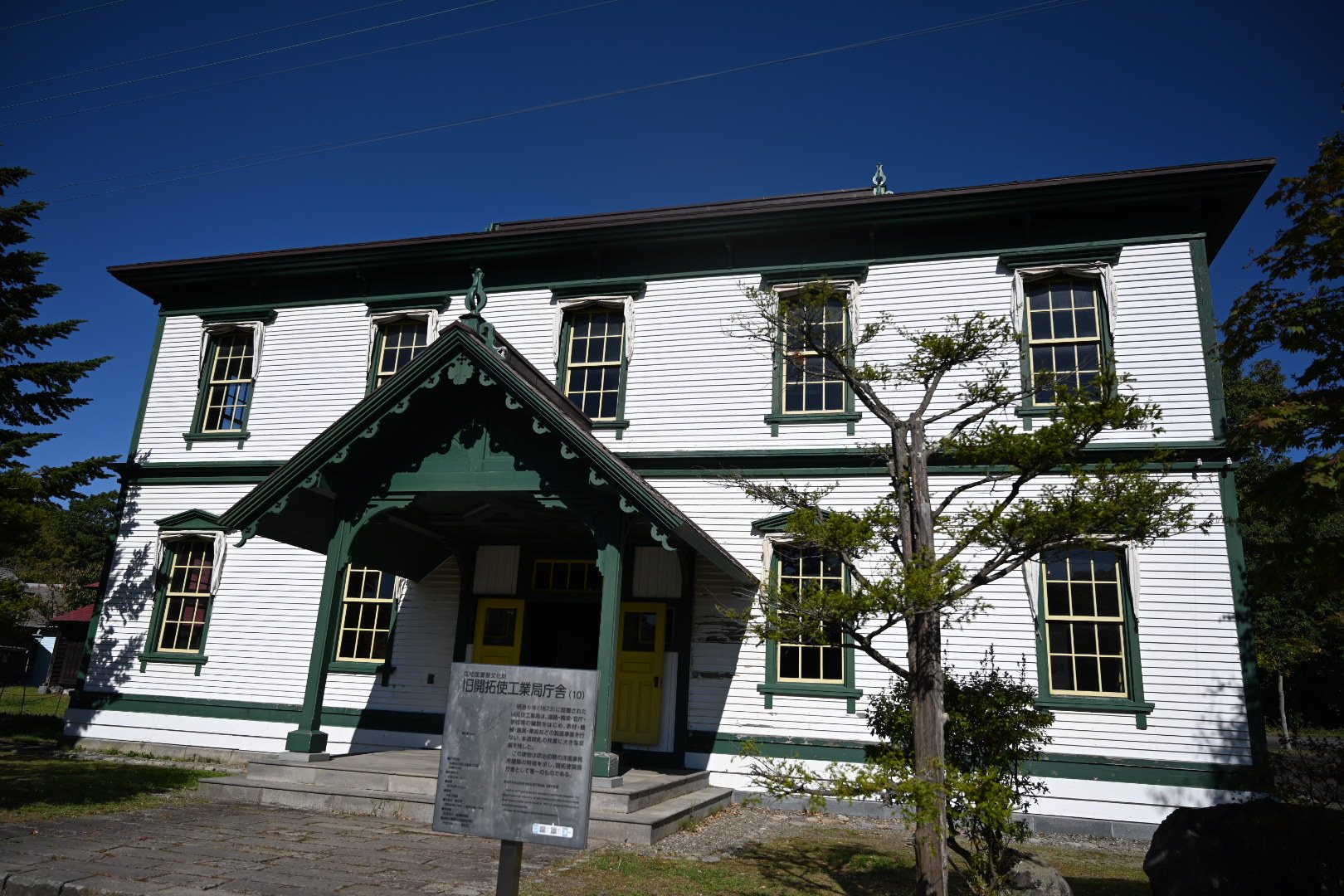 北海道開拓の村の旧開拓使工業局庁舎。白い壁に緑の縁取り、黄色い扉の玄関