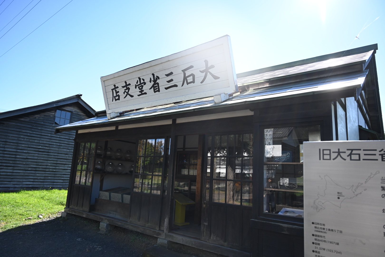 北海道開拓の村の旧大石三省堂支店。白い看板のかかる木造の菓子店