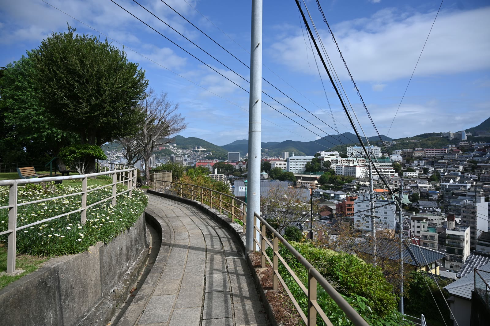 南山手の高台の石畳の遊歩道。手すりの向こうに長崎の町