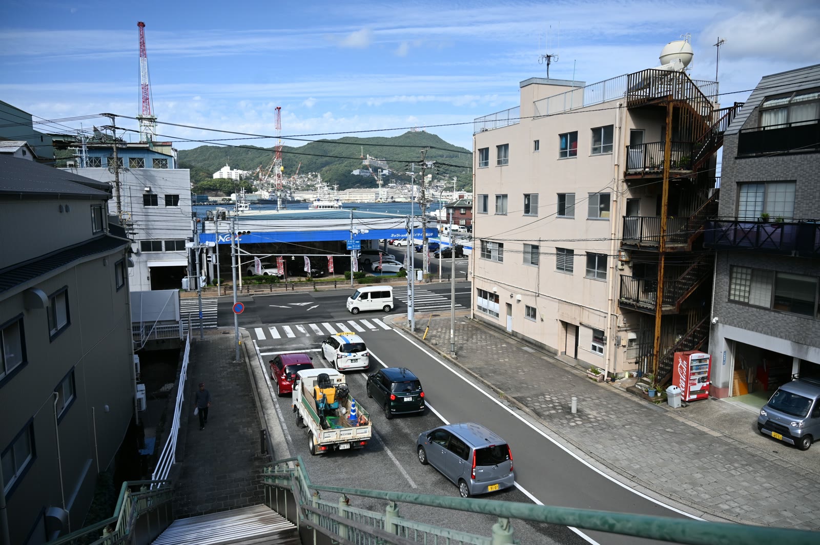 階段の上から見た港の近くの通りと、造船所のクレーン