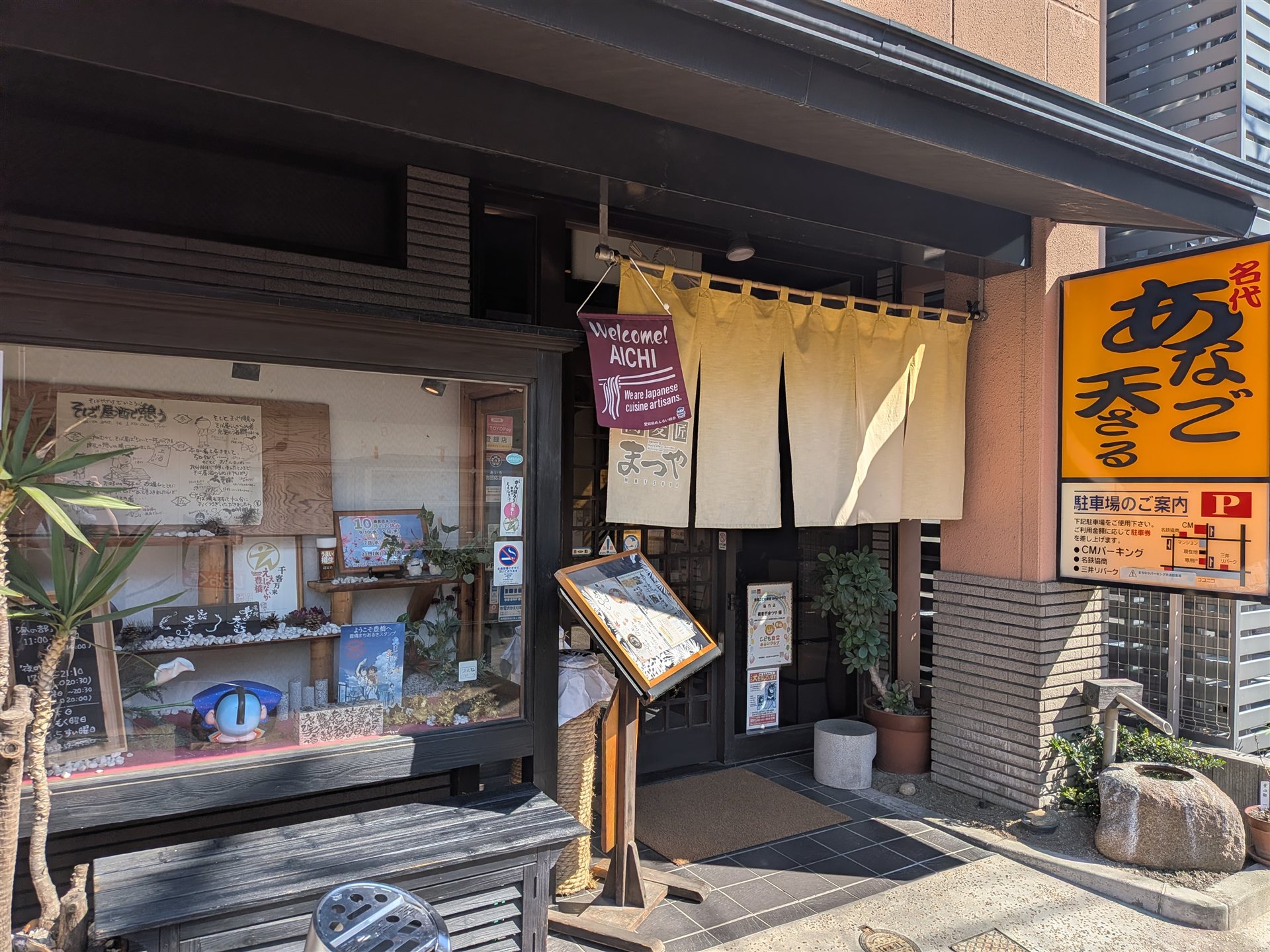 豊橋の麦匠 まつやの入口。黄色いのれんと「名代 あなご天ざる」の看板